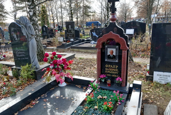 Памятник из чёрного гранита и низкая арка на круглых колоннах
